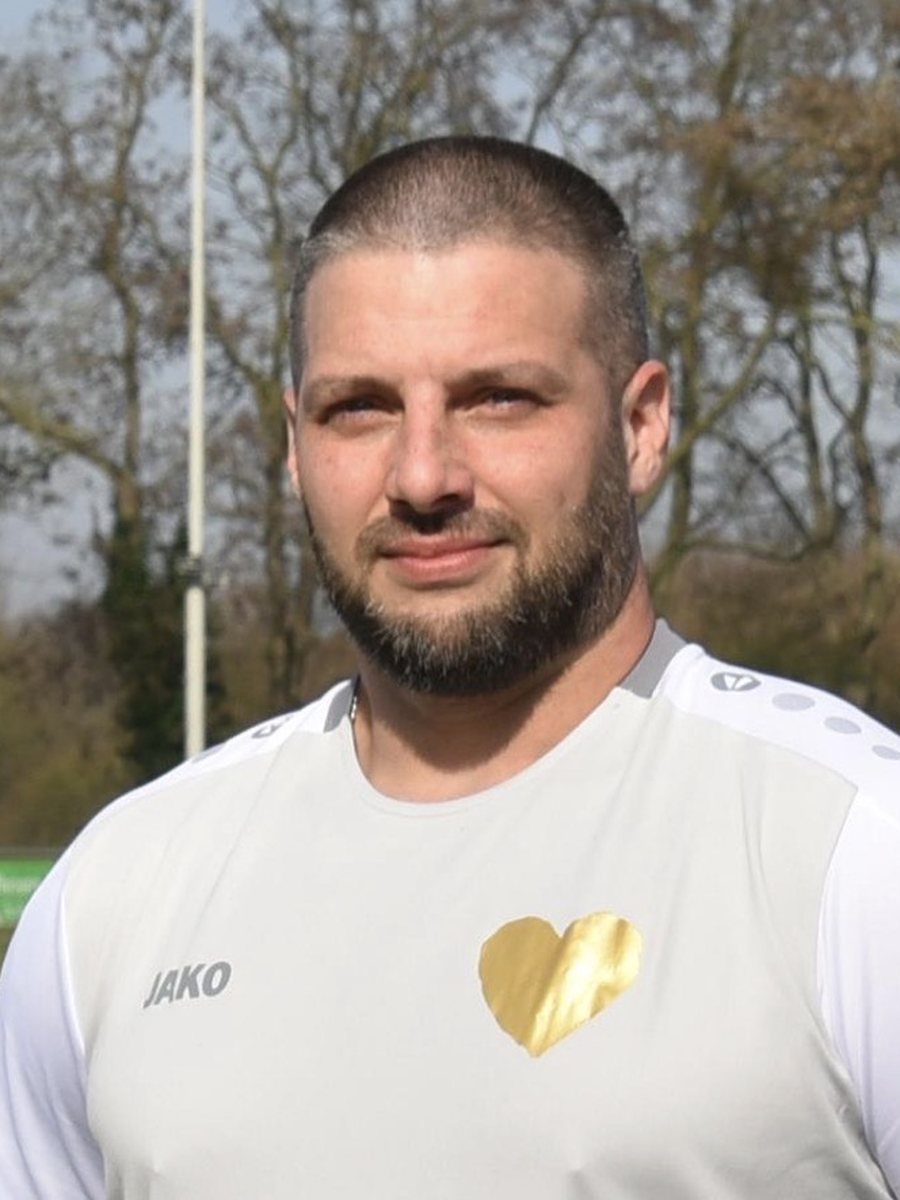 Pascal im weißen Trikot der Inklusionsmannschaft auf dem Sportplatz